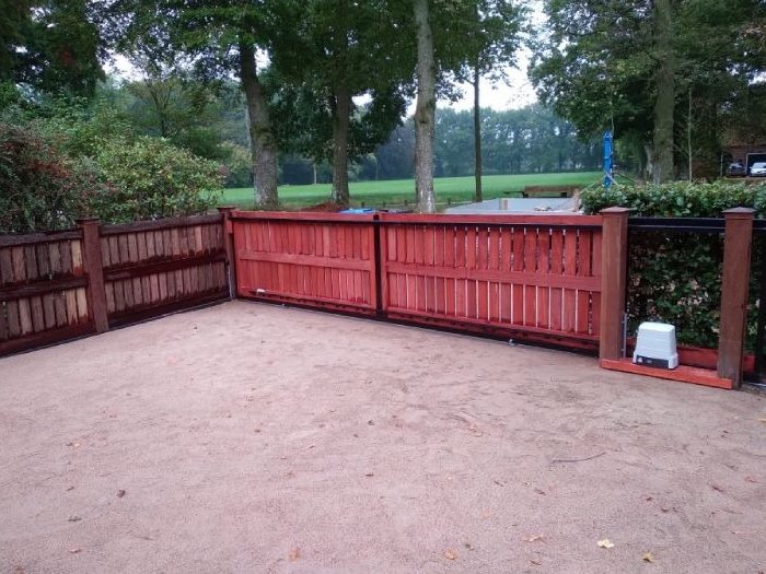 Geniet van de unieke uitstraling van een padouk houten schuifpoort Een houten schuifpoort van padouk.